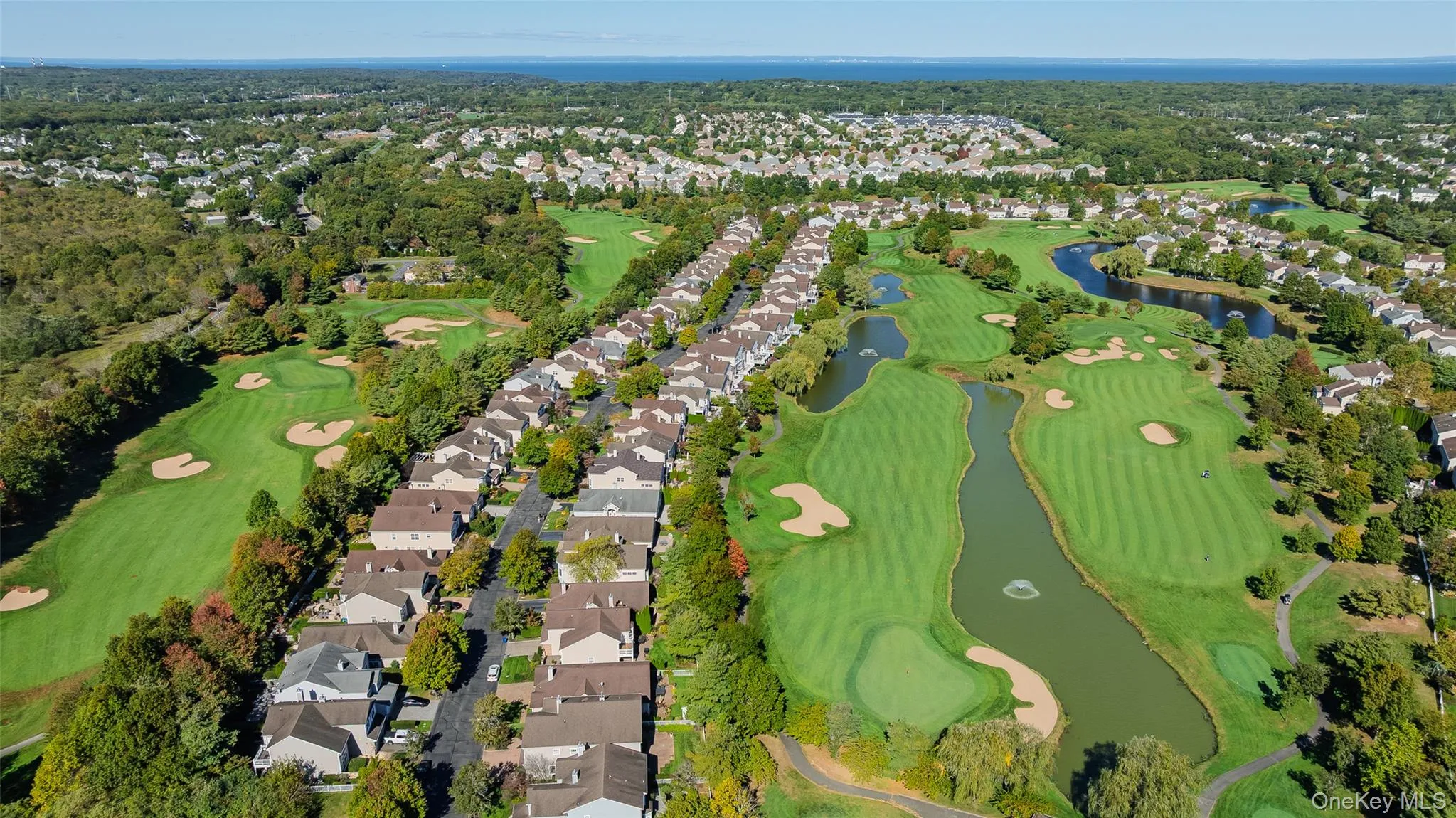 Aerial overview of property's location featuring a large body of water and nearby suburban area Aerial overview of property's location featuring a large body of water and nearby suburban area