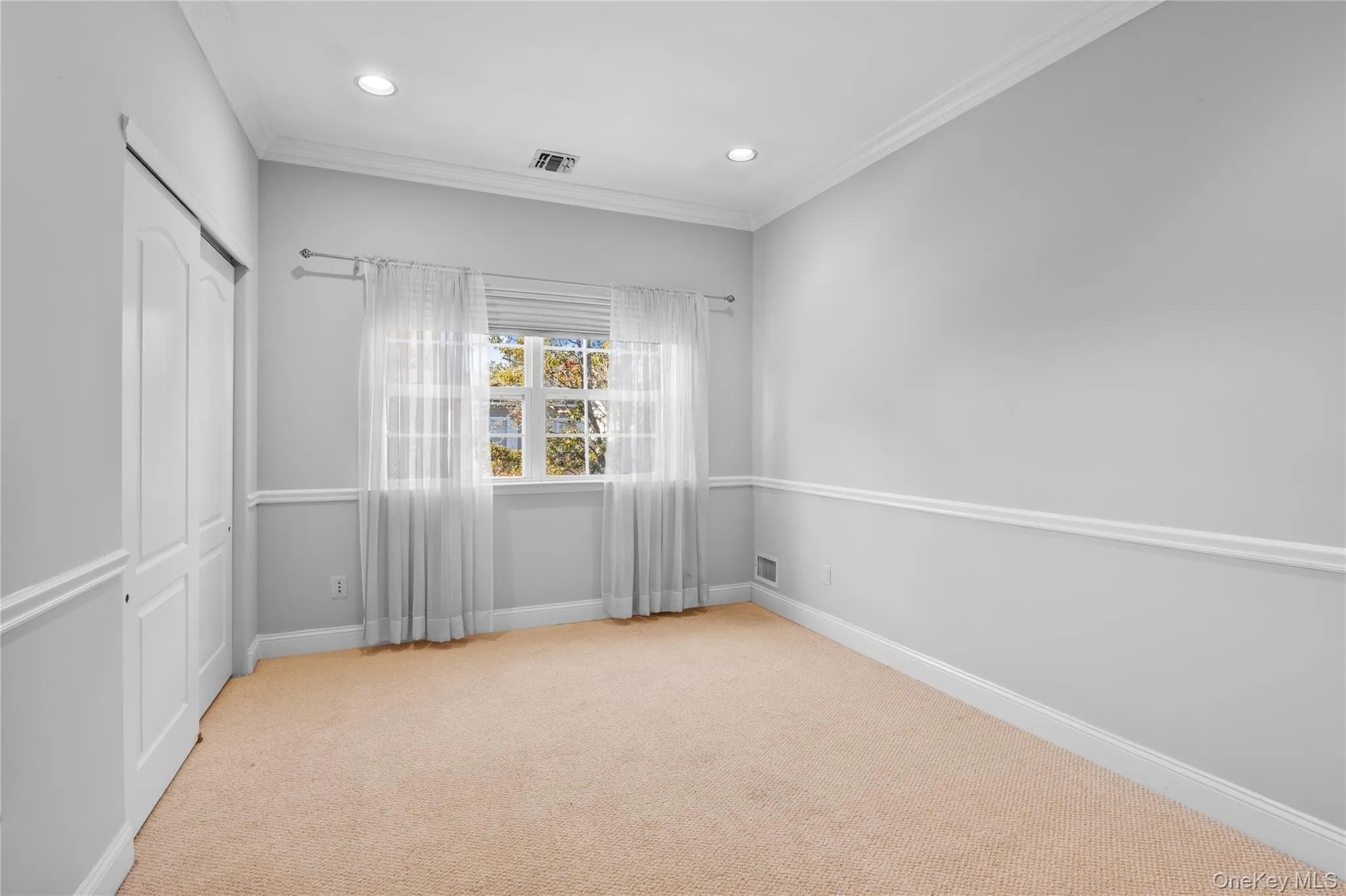 Unfurnished bedroom with light carpet, crown molding, a closet, and recessed lighting Unfurnished bedroom with light carpet, crown molding, a closet, and recessed lighting