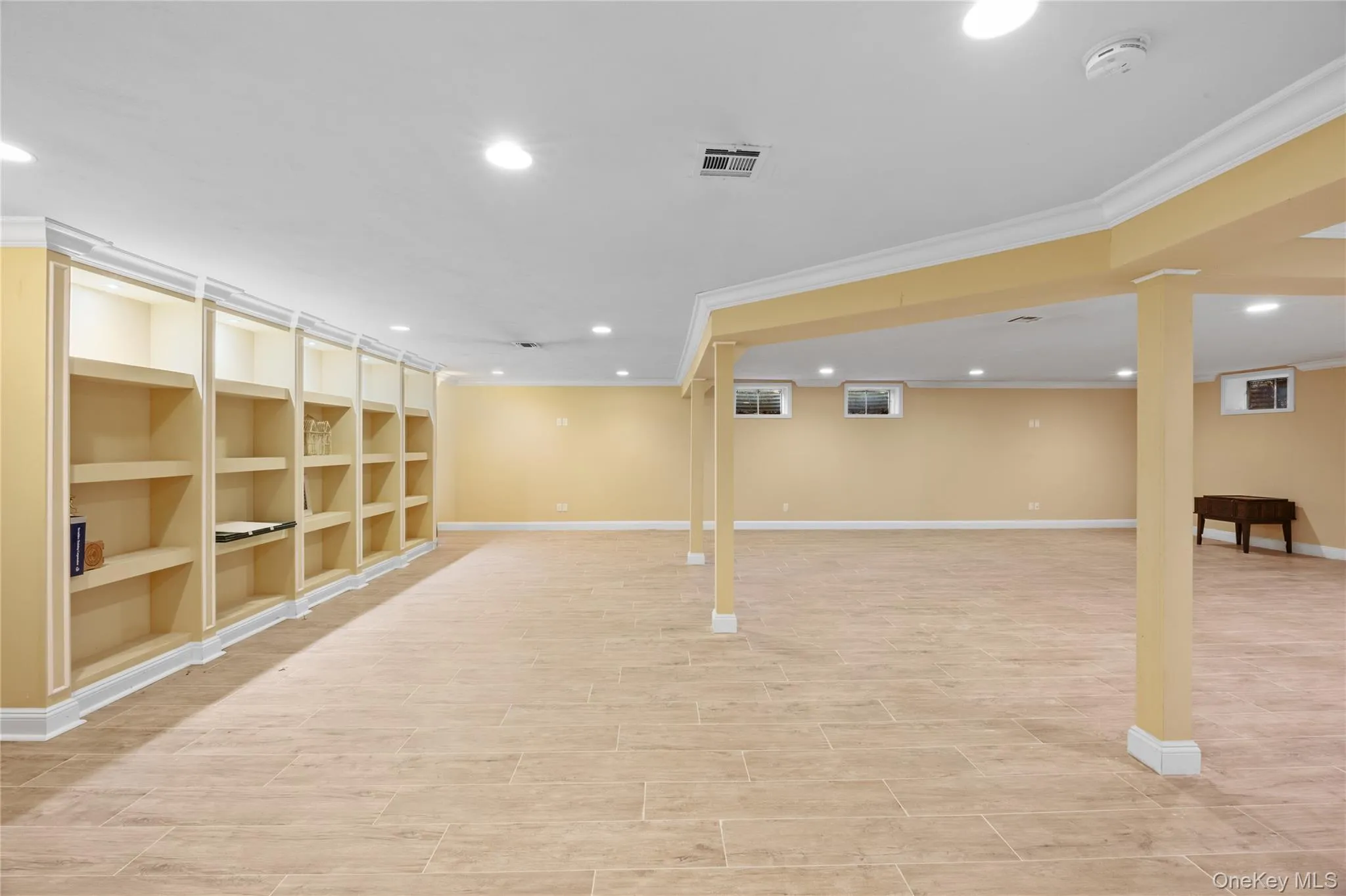 Finished below grade area featuring recessed lighting, crown molding, and wood finish floors Finished below grade area featuring recessed lighting, crown molding, and wood finish floors