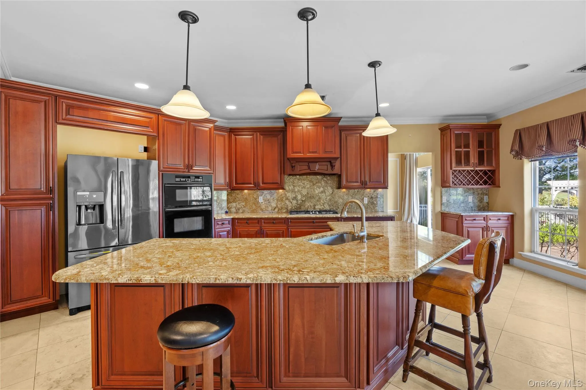 Kitchen featuring a breakfast bar, decorative backsplash, light tile patterned flooring, stainless steel refrigerator with ice dispenser, and ornamental molding Kitchen featuring a breakfast bar, decorative backsplash, light tile patterned flooring, stainless steel refrigerator with ice dispenser, and ornamental molding
