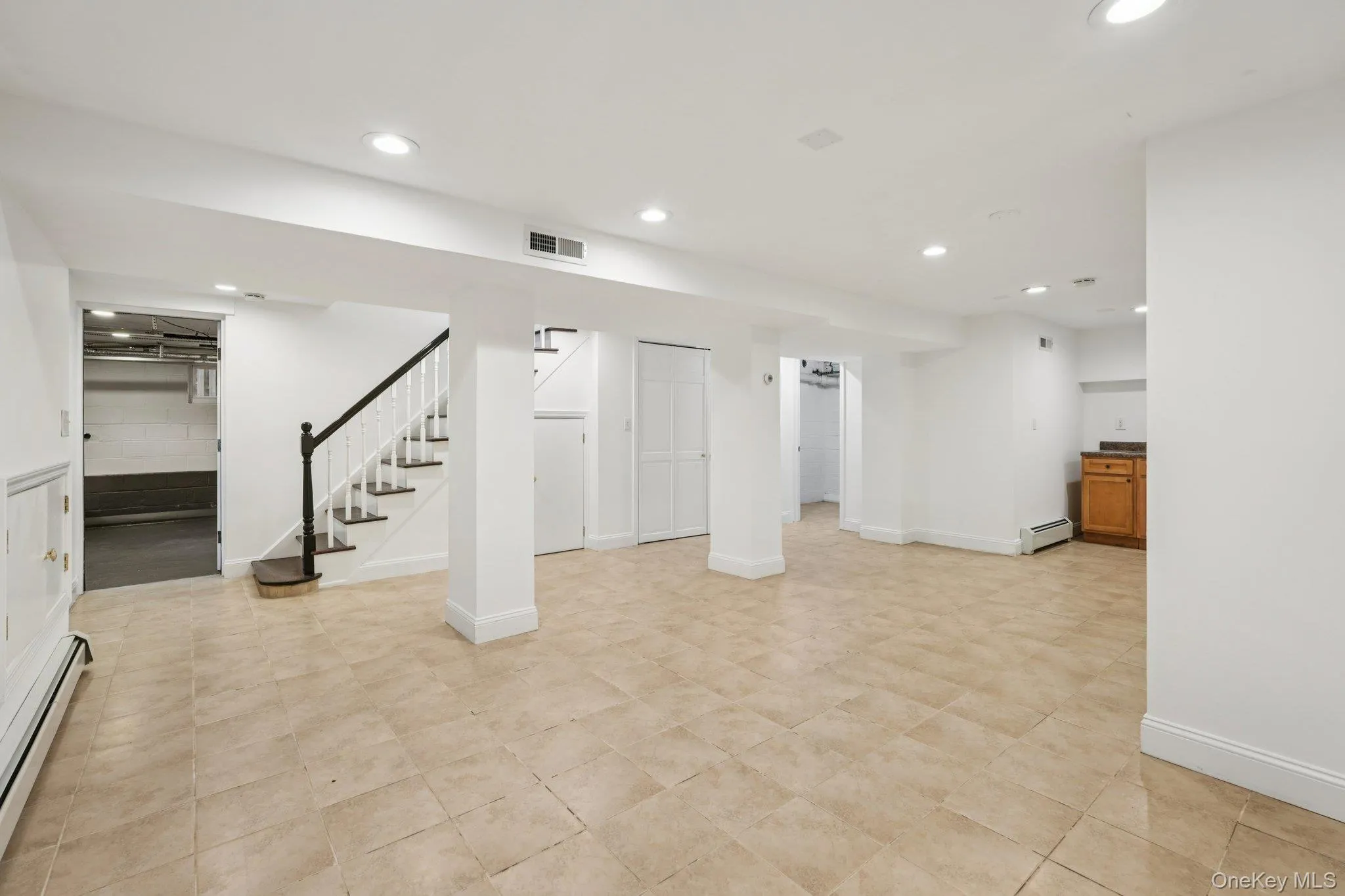 Finished below grade area with stairs, a baseboard radiator, recessed lighting, and baseboard heating Finished below grade area with stairs, a baseboard radiator, recessed lighting, and baseboard heating