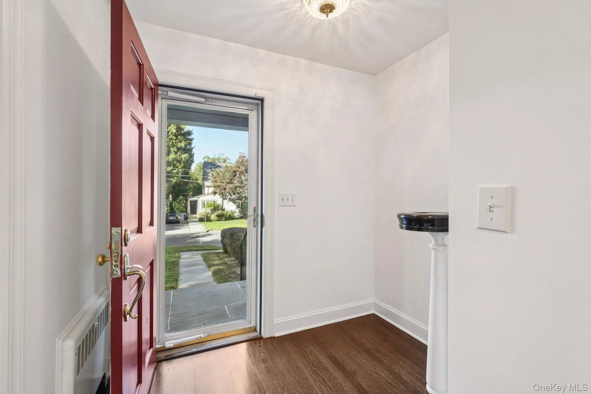 Entryway featuring wood finished floors and radiator Entryway featuring wood finished floors and radiator