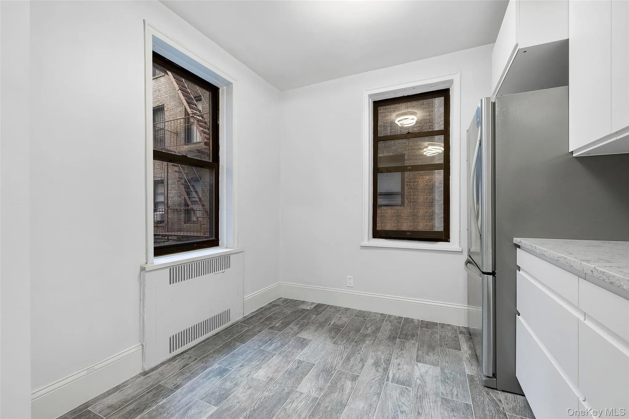 Unfurnished dining area with wood tiled floors and radiator heating unit Unfurnished dining area with wood tiled floors and radiator heating unit