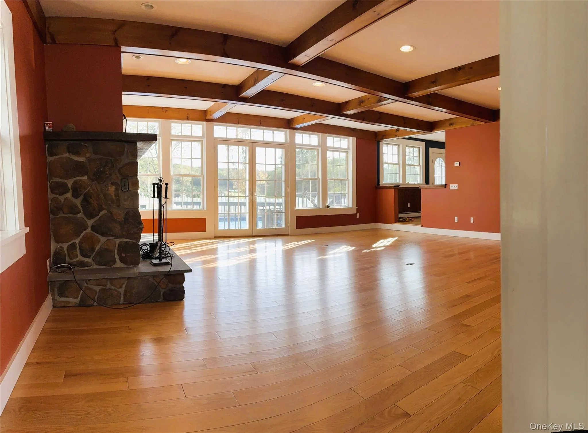 Living area featuring beamed ceiling, light wood finished floors, coffered ceiling, and recessed lighting Living area featuring beamed ceiling, light wood finished floors, coffered ceiling, and recessed lighting