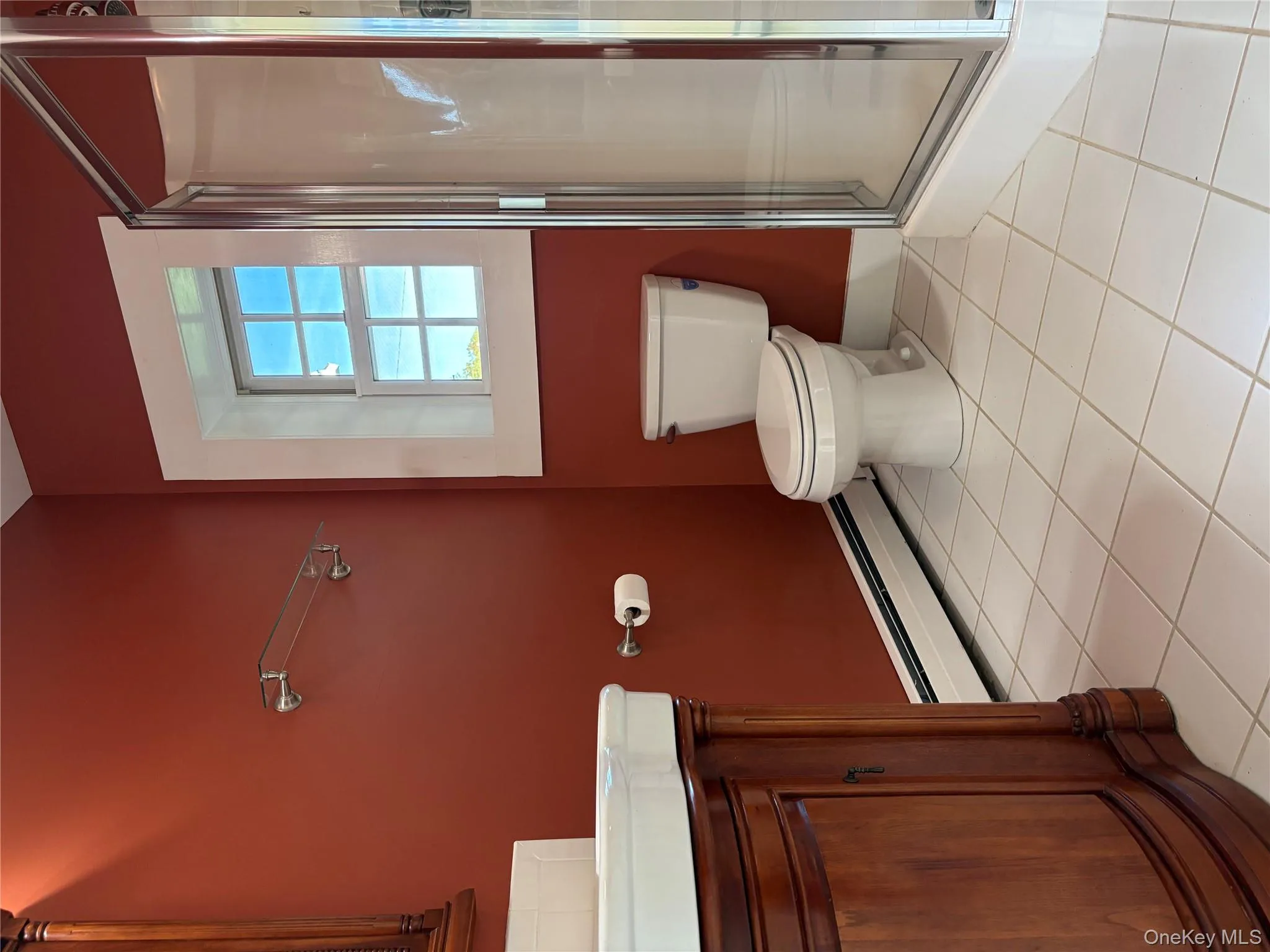 Bathroom featuring baseboard heating, vanity, light tile patterned floors, and a stall shower Bathroom featuring baseboard heating, vanity, light tile patterned floors, and a stall shower
