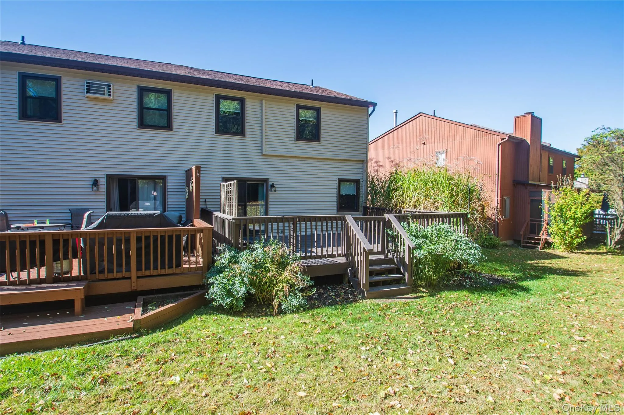 Back of property with a wooden deck and a lawn Back of property with a wooden deck and a lawn