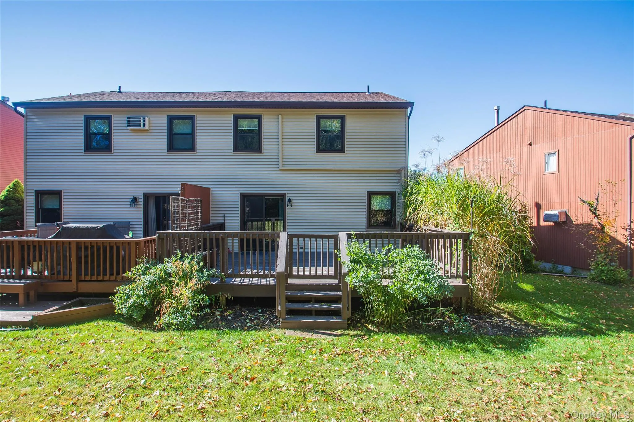Rear view of house with a yard and a wooden deck Rear view of house with a yard and a wooden deck