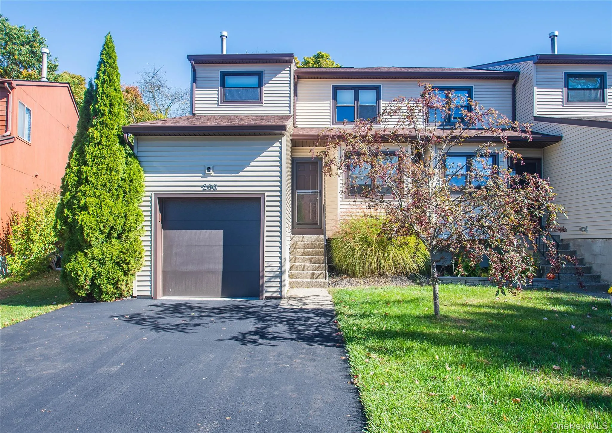Traditional-style home featuring a front lawn, driveway, and an attached garage Traditional-style home featuring a front lawn, driveway, and an attached garage