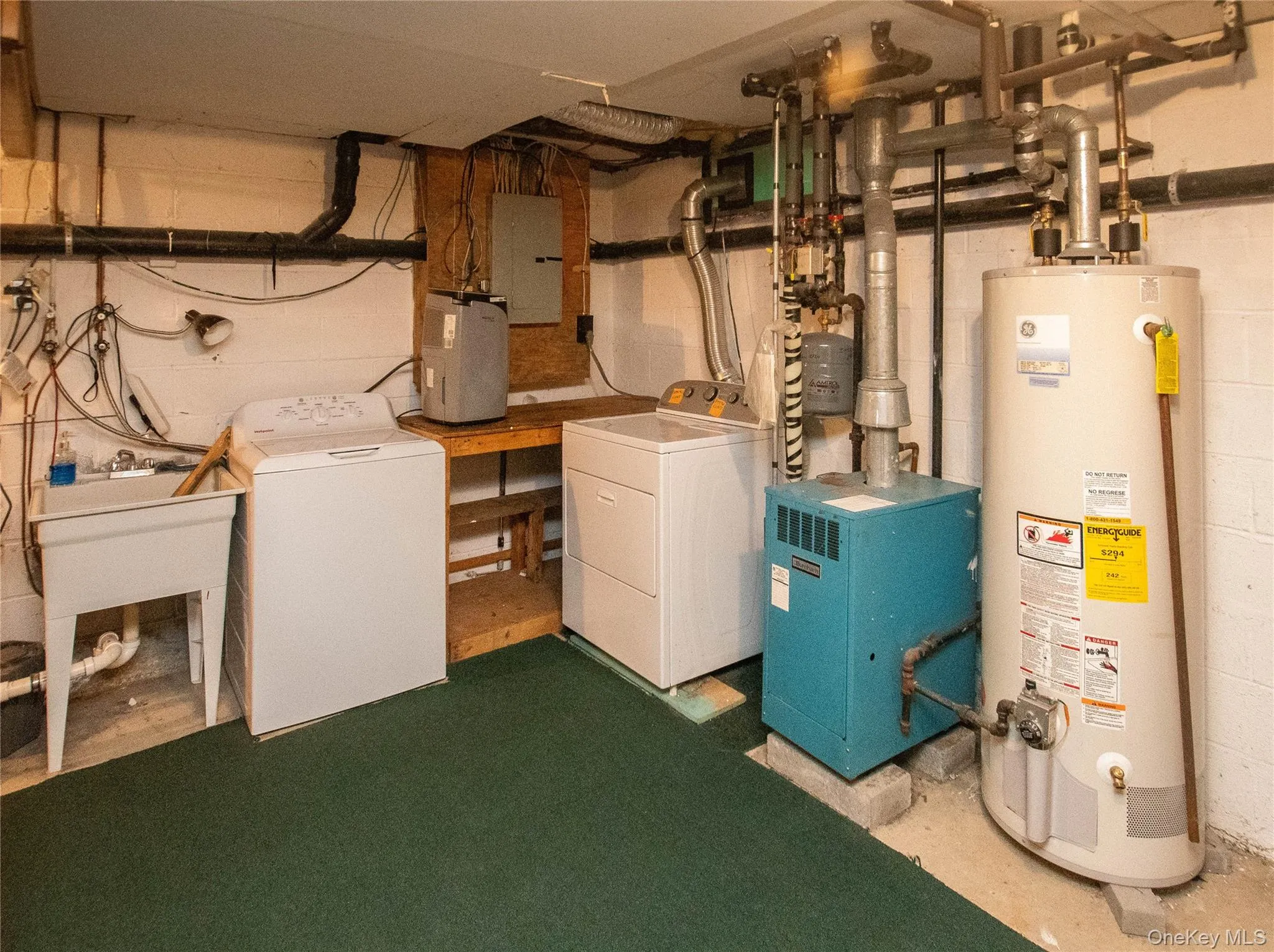 Utility room with gas water heater, washing machine and dryer, and electric panel Utility room with gas water heater, washing machine and dryer, and electric panel