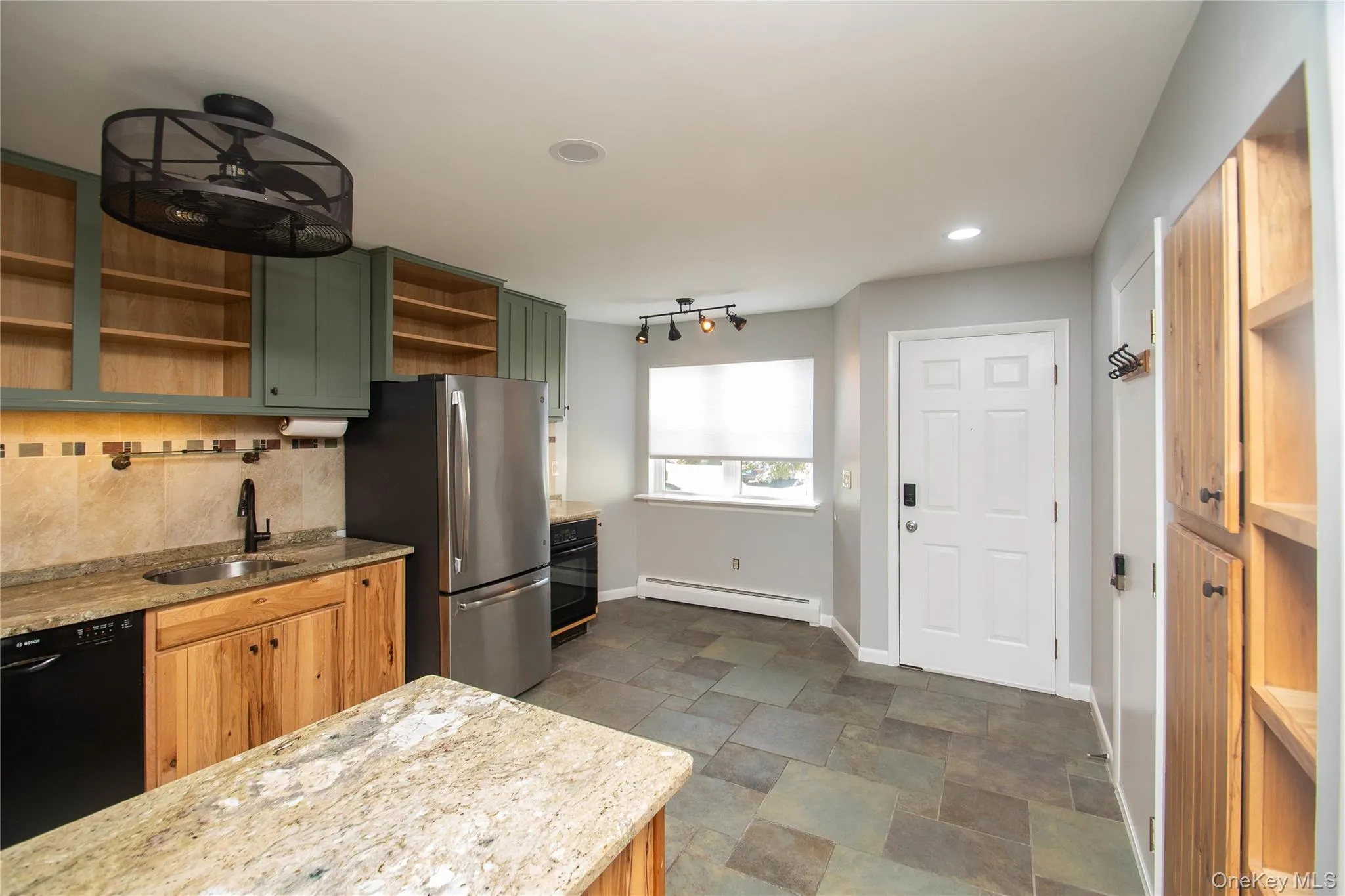 Kitchen with open shelves, green cabinets, decorative backsplash, dishwasher, and freestanding refrigerator Kitchen with open shelves, green cabinets, decorative backsplash, dishwasher, and freestanding refrigerator