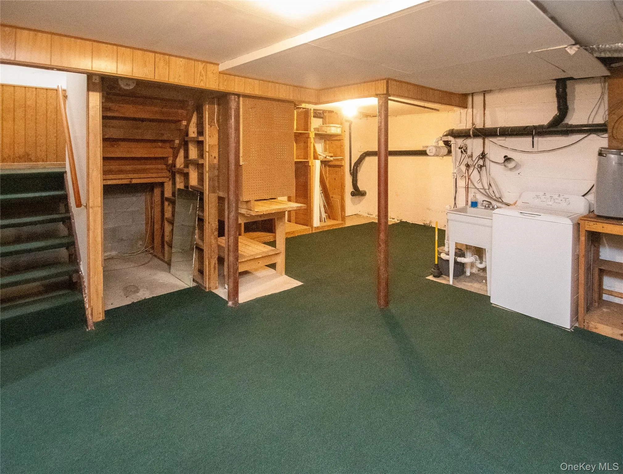 Below grade area featuring stairs, washer / dryer, and carpet Below grade area featuring stairs, washer / dryer, and carpet
