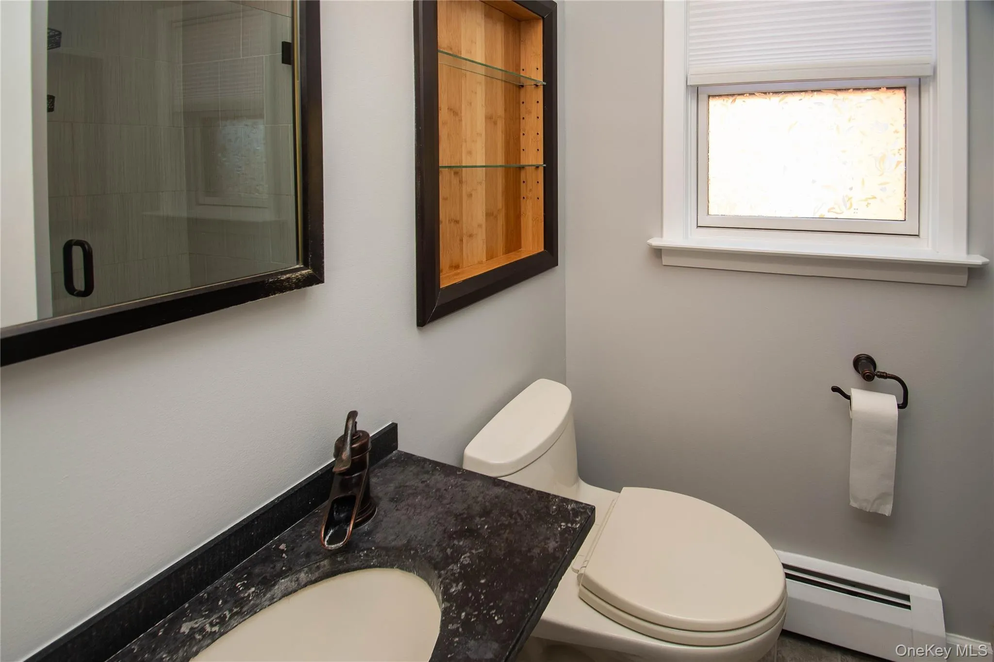 Bathroom featuring a baseboard heating unit, a stall shower, and vanity Bathroom featuring a baseboard heating unit, a stall shower, and vanity