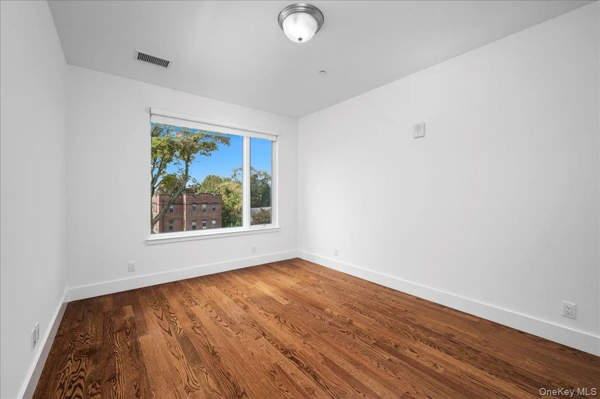 Bedroom room with wood finished floors and baseboards Bedroom room with wood finished floors and baseboards