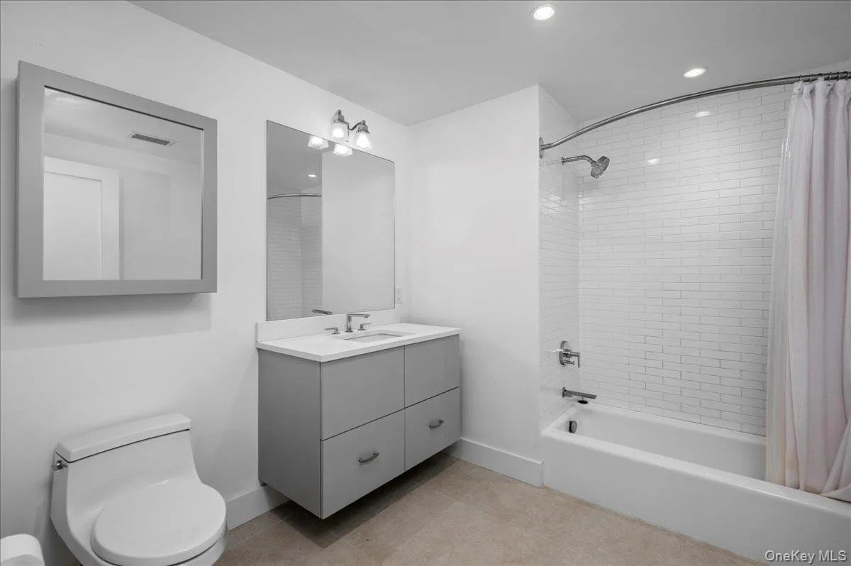 Full bathroom with shower / tub combo, vanity, recessed lighting, and light tile patterned floors Full bathroom with shower / tub combo, vanity, recessed lighting, and light tile patterned floors