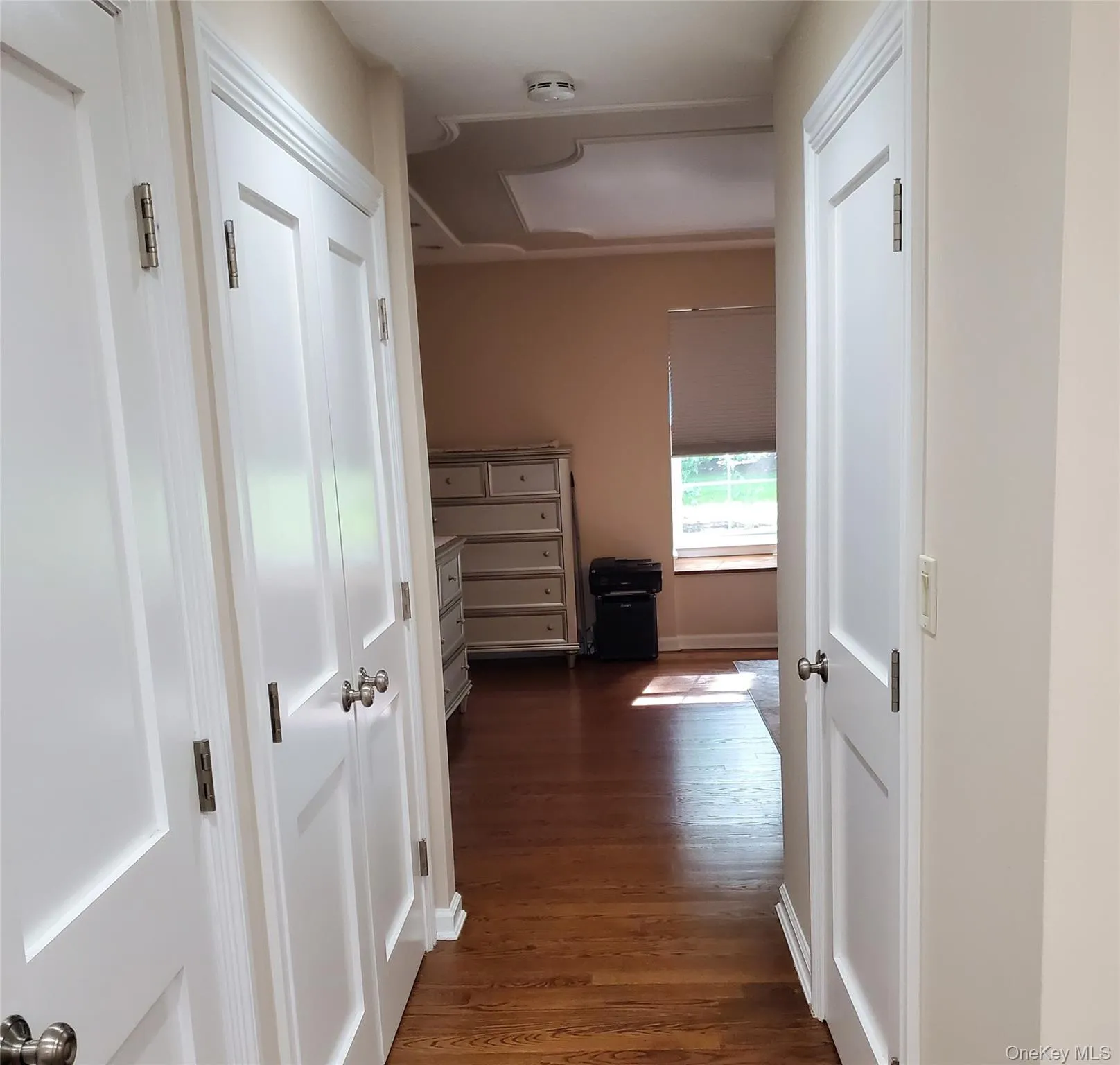 Corridor featuring dark wood finished floors and baseboards Corridor featuring dark wood finished floors and baseboards
