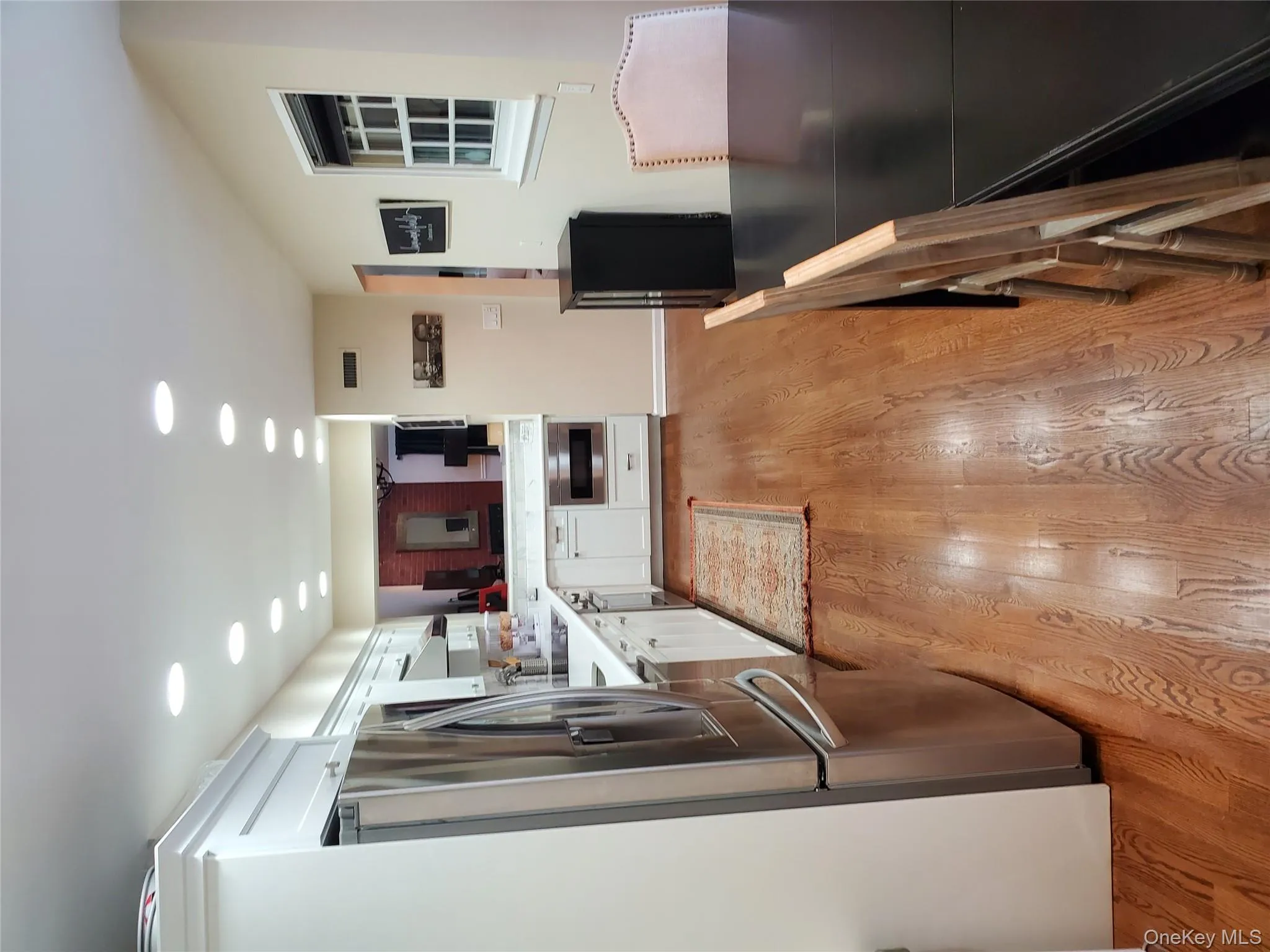 Kitchen featuring white cabinets, recessed lighting, stainless steel refrigerator, light wood-style floors, and wall oven Kitchen featuring white cabinets, recessed lighting, stainless steel refrigerator, light wood-style floors, and wall oven