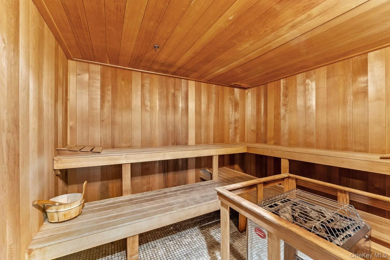 Relaxing sauna featuring wooden ceiling, tile patterned flooring, and wood walls Relaxing sauna featuring wooden ceiling, tile patterned flooring, and wood walls
