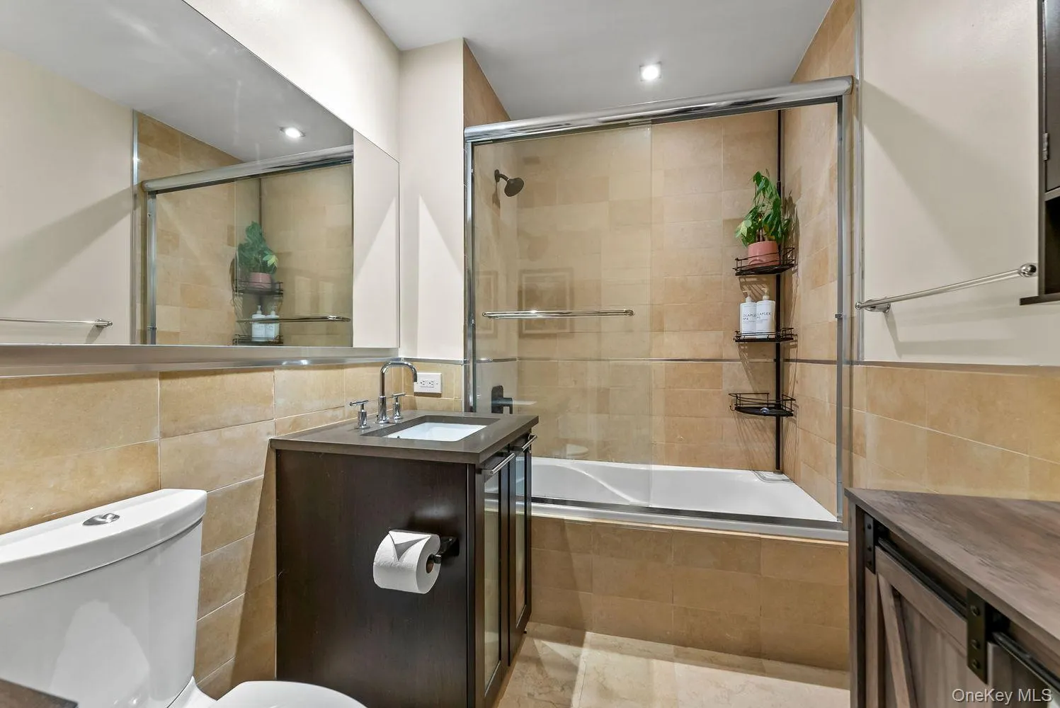 Full bath with tile walls, tiled shower / bath combo, vanity, and recessed lighting Full bath with tile walls, tiled shower / bath combo, vanity, and recessed lighting