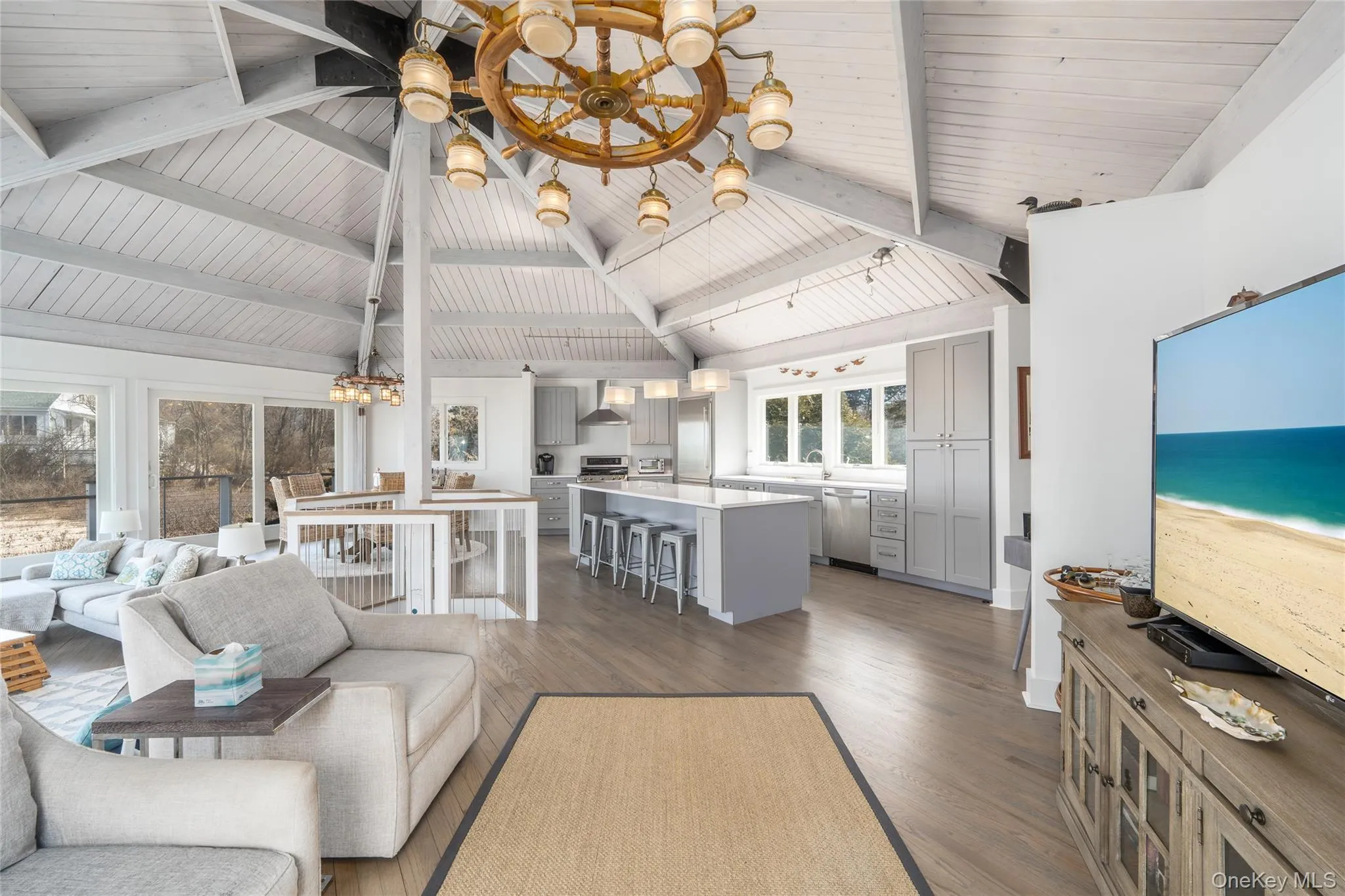 Living area with lofted ceiling with beams, a ceiling fan, wooden ceiling, and dark wood-style flooring Living area with lofted ceiling with beams, a ceiling fan, wooden ceiling, and dark wood-style flooring