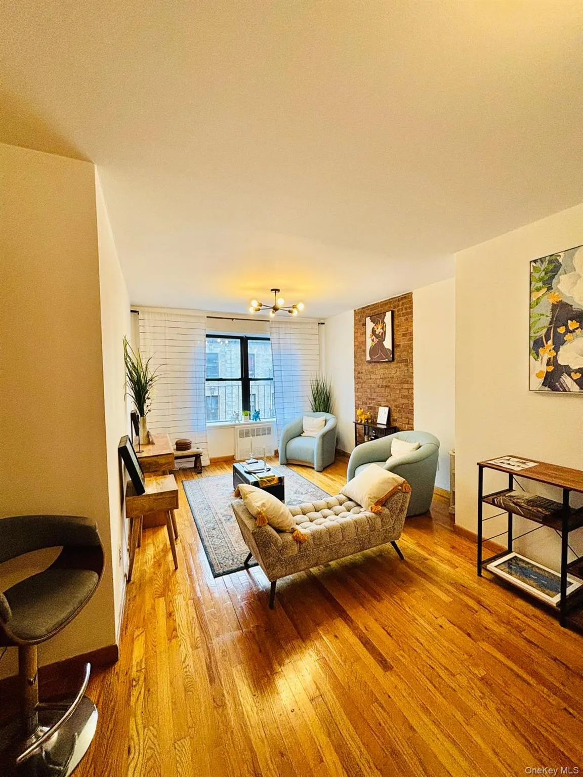 Living room with light wood-type flooring, a chandelier, and radiator heating unit Living room with light wood-type flooring, a chandelier, and radiator heating unit