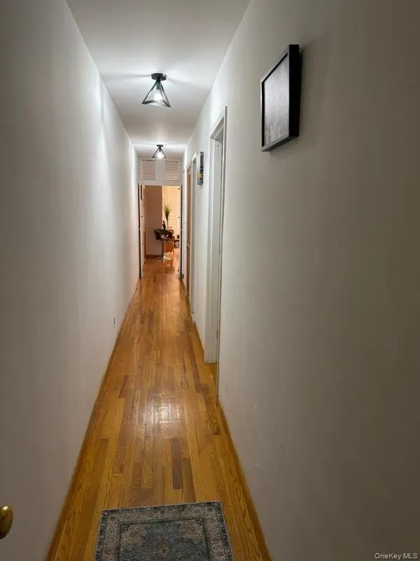 Corridor with wood finished floors and baseboards Corridor with wood finished floors and baseboards