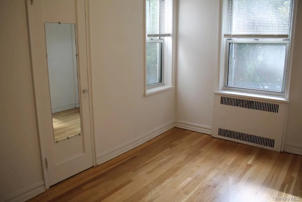 Spare room featuring radiator and light wood-style flooring Spare room featuring radiator and light wood-style flooring