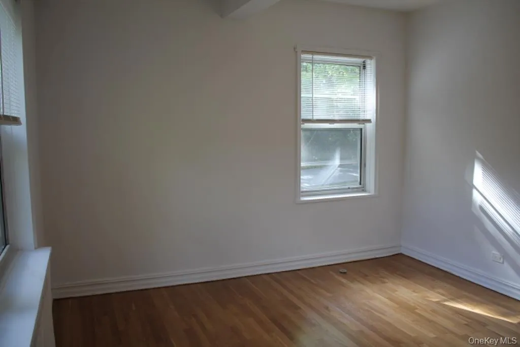 Spare room featuring light wood-style floors and baseboards Spare room featuring light wood-style floors and baseboards