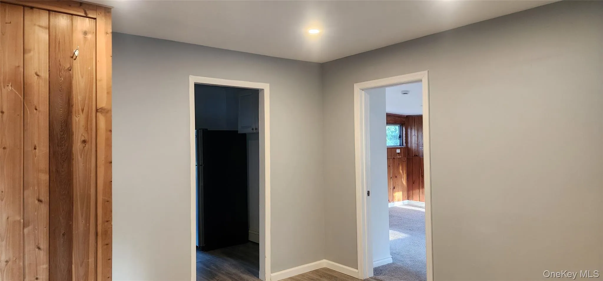 Hallway featuring wood finished floors and carpet flooring Hallway featuring wood finished floors and carpet flooring