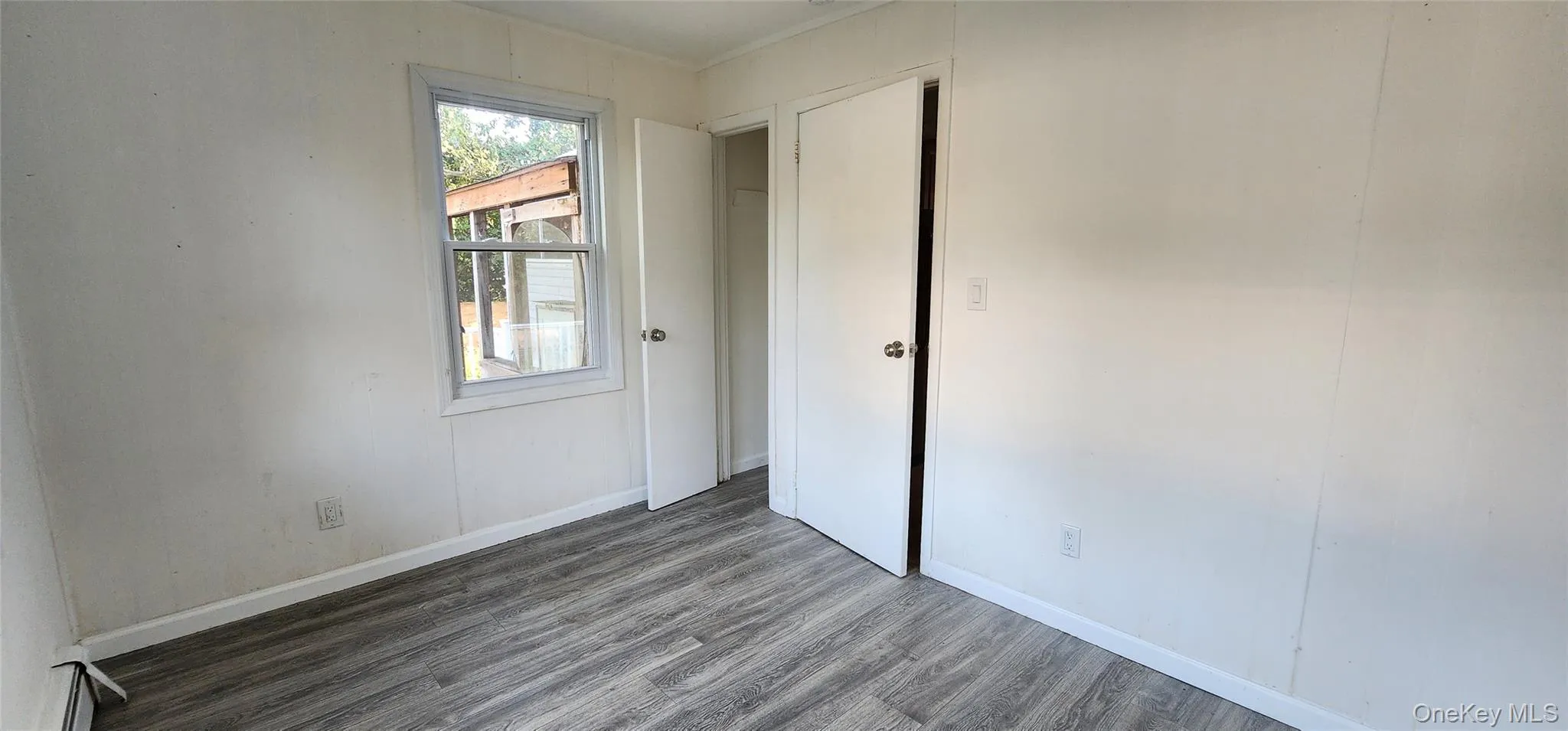 Empty room featuring wood finished floors and baseboards Empty room featuring wood finished floors and baseboards