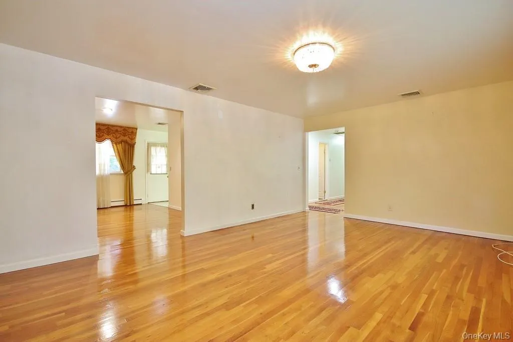 Spare room with light wood-style flooring and baseboards Spare room with light wood-style flooring and baseboards