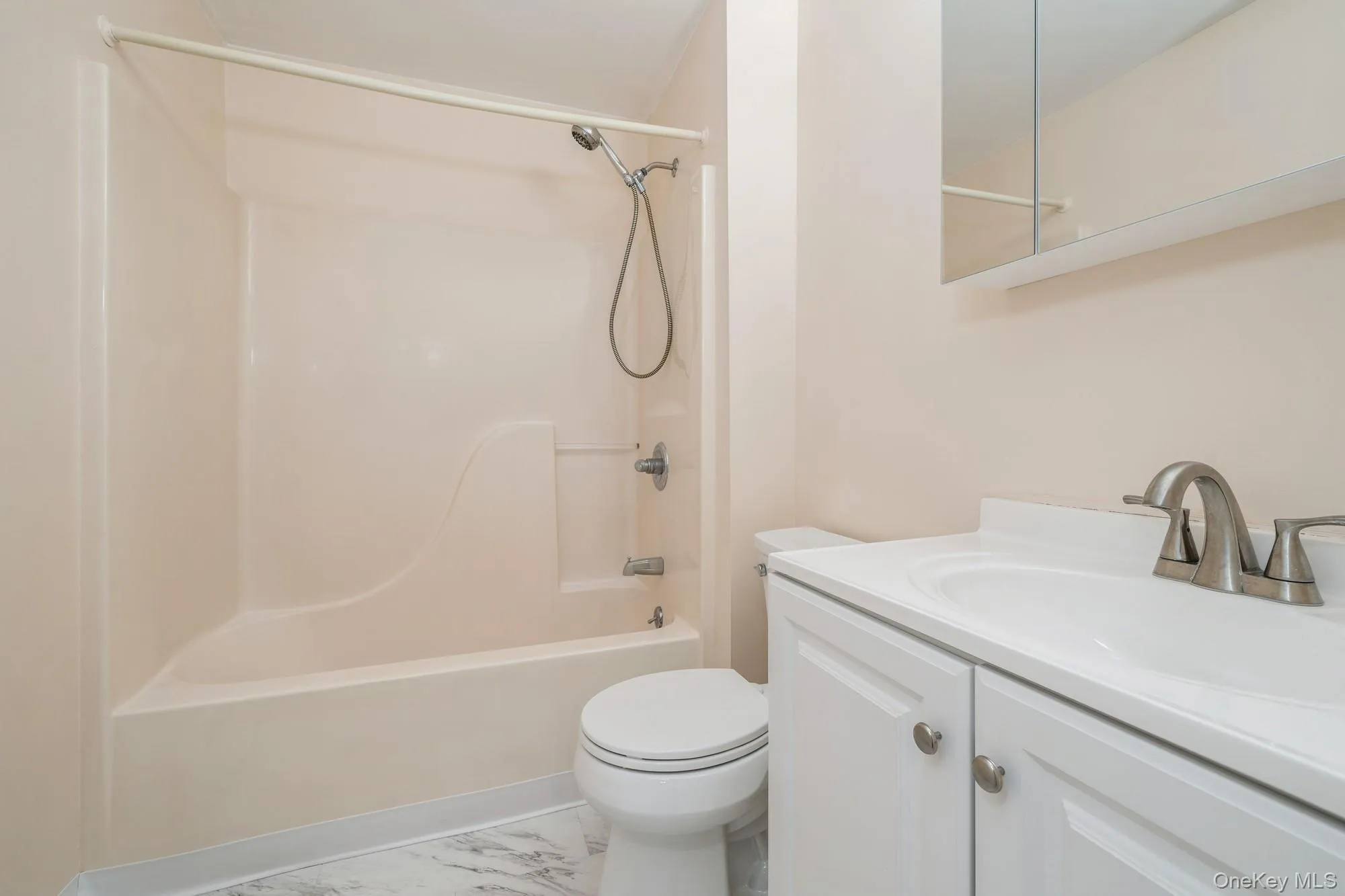 Full bath with vanity, bathtub / shower combination, and light marble finish flooring Full bath with vanity, bathtub / shower combination, and light marble finish flooring