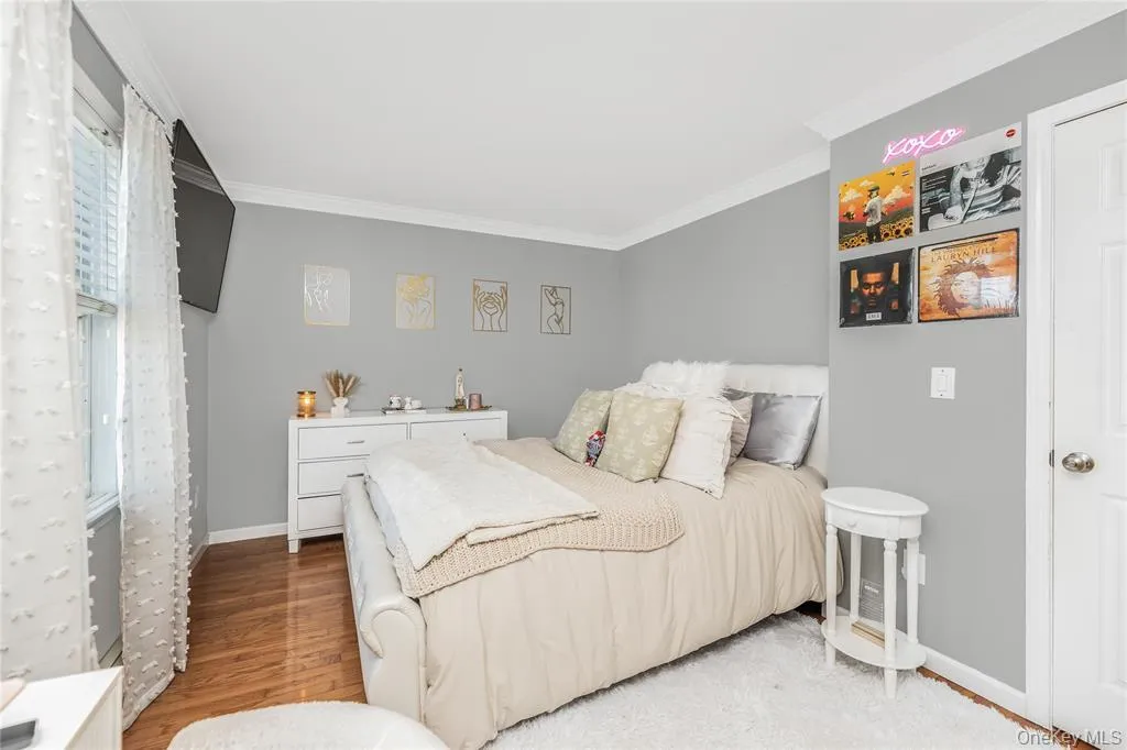 Bedroom featuring crown molding and light wood finished floors Bedroom featuring crown molding and light wood finished floors