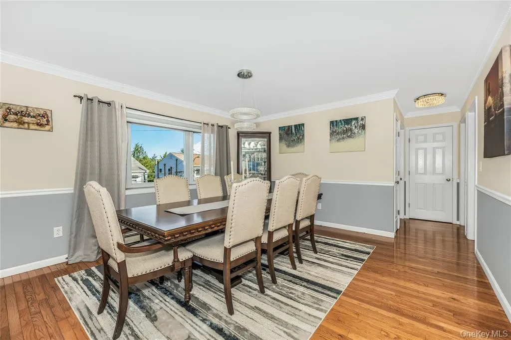 Dining area with ornamental molding and wood finished floors Dining area with ornamental molding and wood finished floors