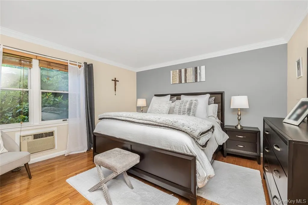 Bedroom featuring ornamental molding and light wood finished floors Bedroom featuring ornamental molding and light wood finished floors