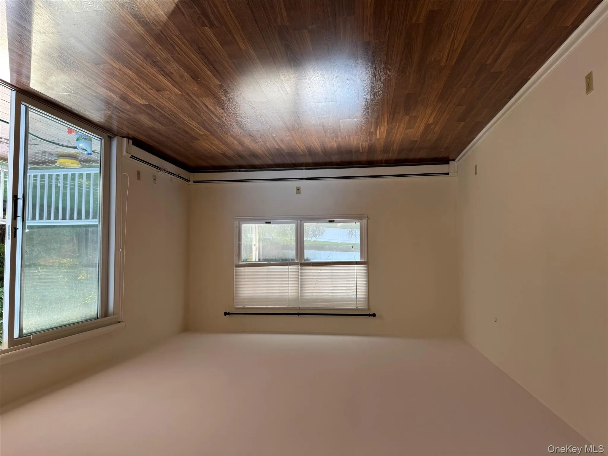 Spare room with dark wood-style flooring and a baseboard heating unit Spare room with dark wood-style flooring and a baseboard heating unit