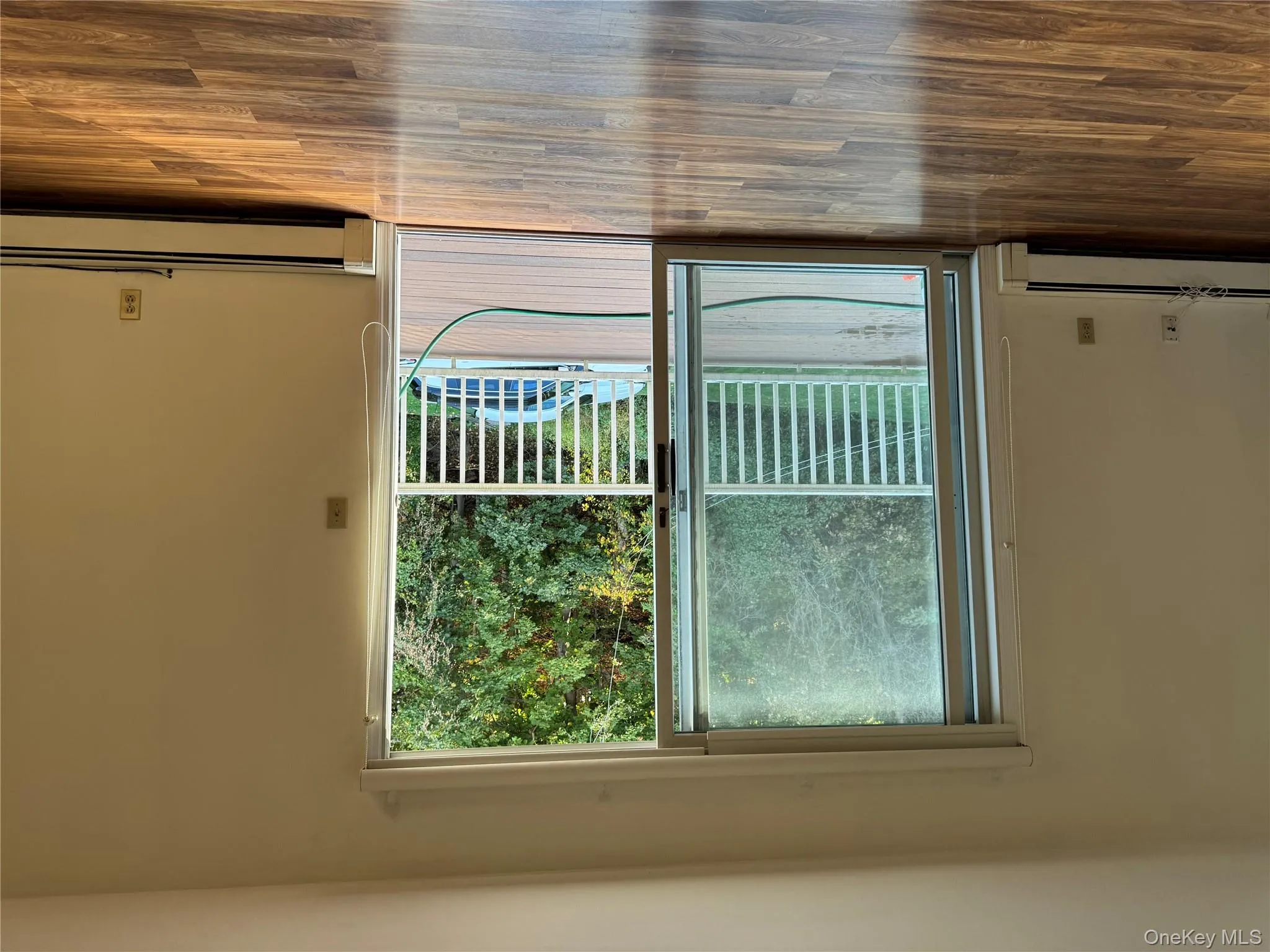 Doorway to outside featuring baseboard heating and wood finished floors Doorway to outside featuring baseboard heating and wood finished floors