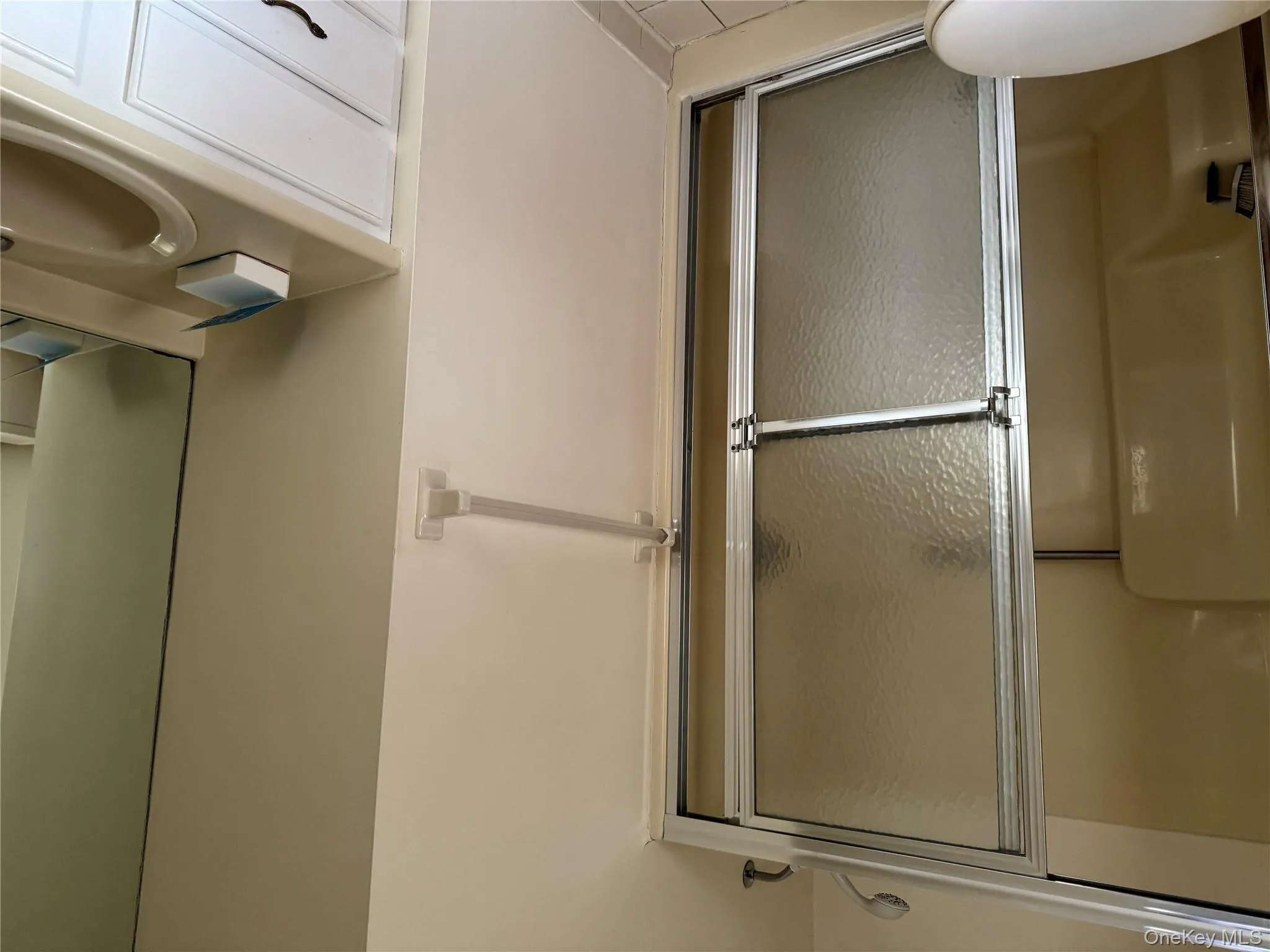 Bathroom featuring vanity, a shower stall, and light tile patterned floors Bathroom featuring vanity, a shower stall, and light tile patterned floors