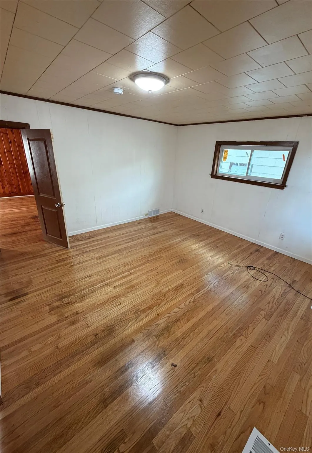 Unfurnished room featuring light wood-style floors and wooden walls Unfurnished room featuring light wood-style floors and wooden walls