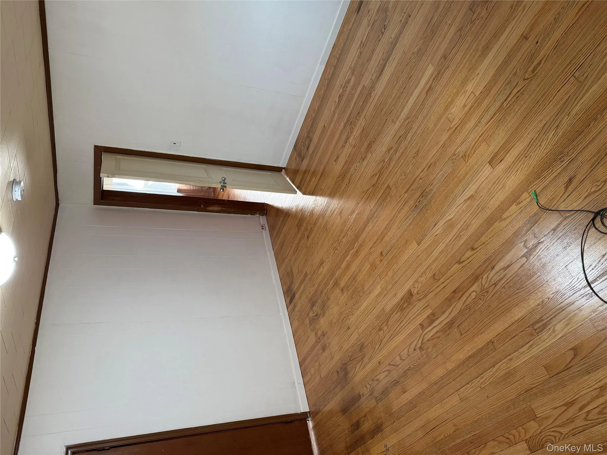 Unfurnished room featuring light wood-style flooring, crown molding, and wooden walls Unfurnished room featuring light wood-style flooring, crown molding, and wooden walls