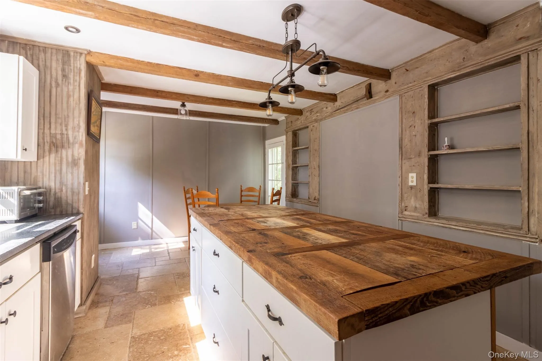 Kitchen featuring white cabinetry, wooden counters, stone tile floors, pendant lighting, and dishwasher Kitchen featuring white cabinetry, wooden counters, stone tile floors, pendant lighting, and dishwasher