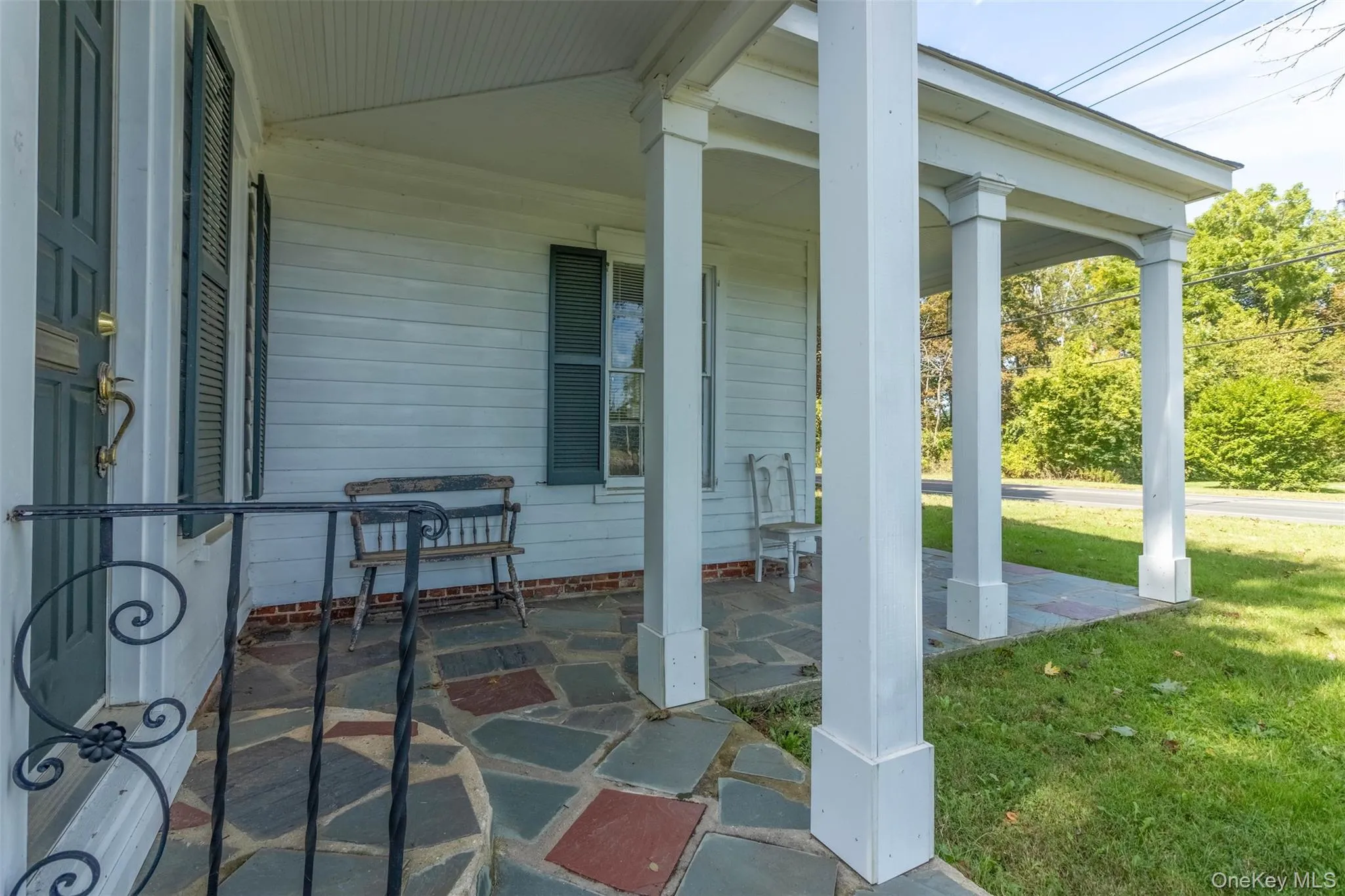 Covered porch featuring a lawn Covered porch featuring a lawn