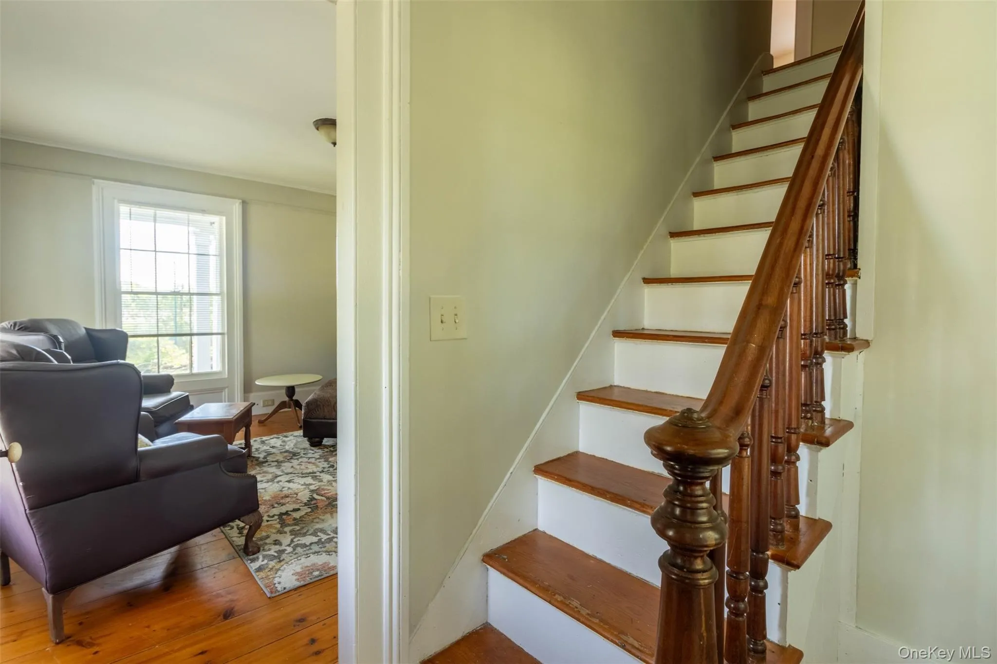 Stairs featuring hardwood / wood-style floors and ornamental molding Stairs featuring hardwood / wood-style floors and ornamental molding