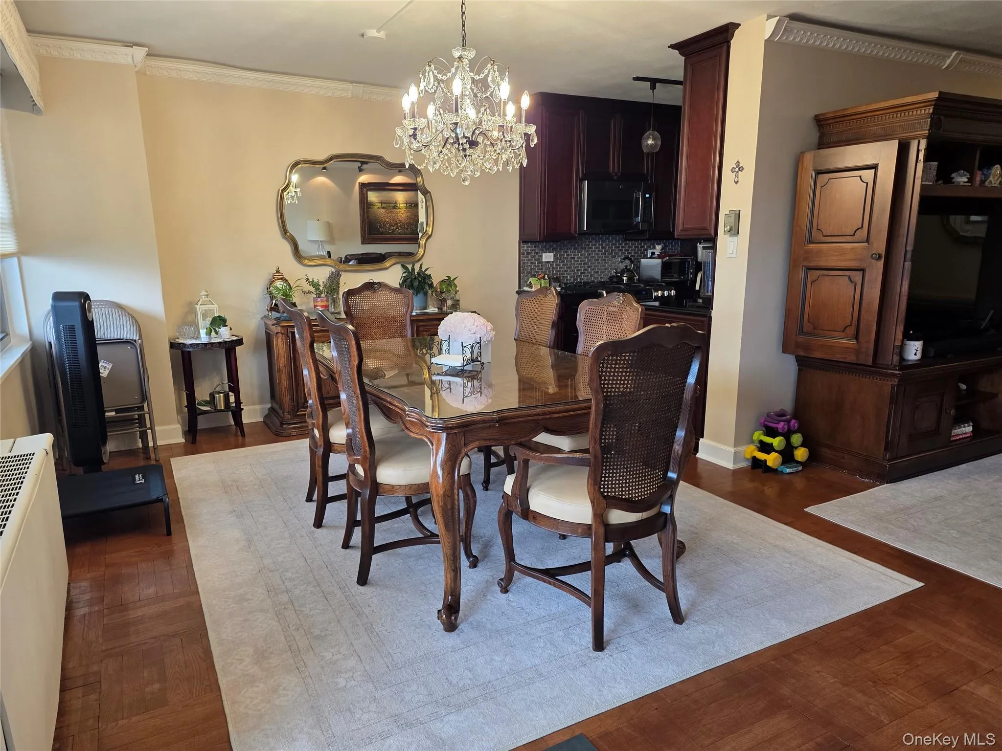 Dining space with a chandelier, crown molding, radiator, and dark wood-style floors Dining space with a chandelier, crown molding, radiator, and dark wood-style floors