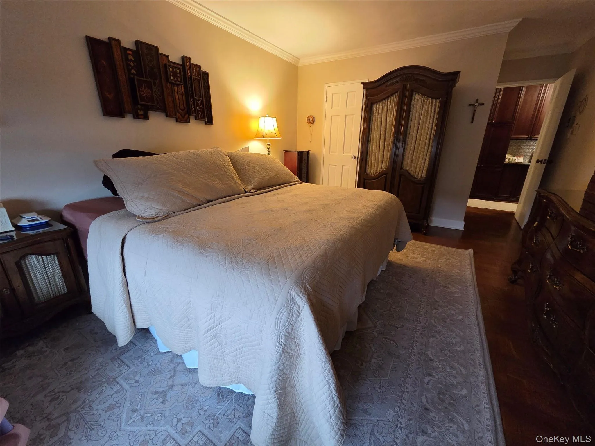 Bedroom with ornamental molding and dark wood-style floors Bedroom with ornamental molding and dark wood-style floors