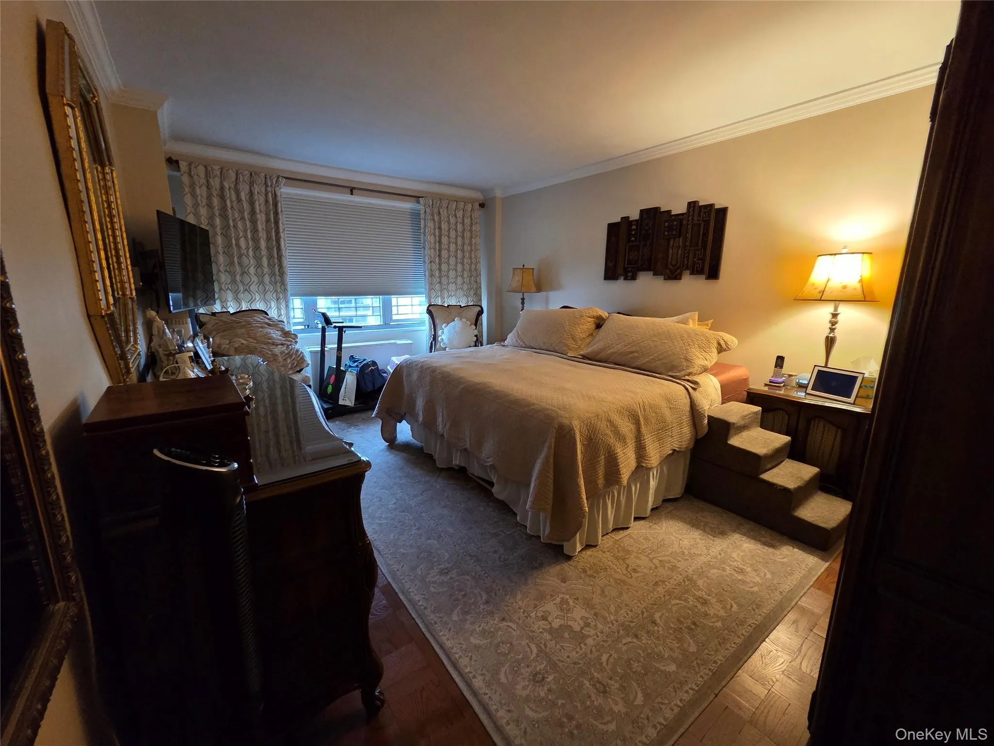 Bedroom with ornamental molding and wood finished floors Bedroom with ornamental molding and wood finished floors