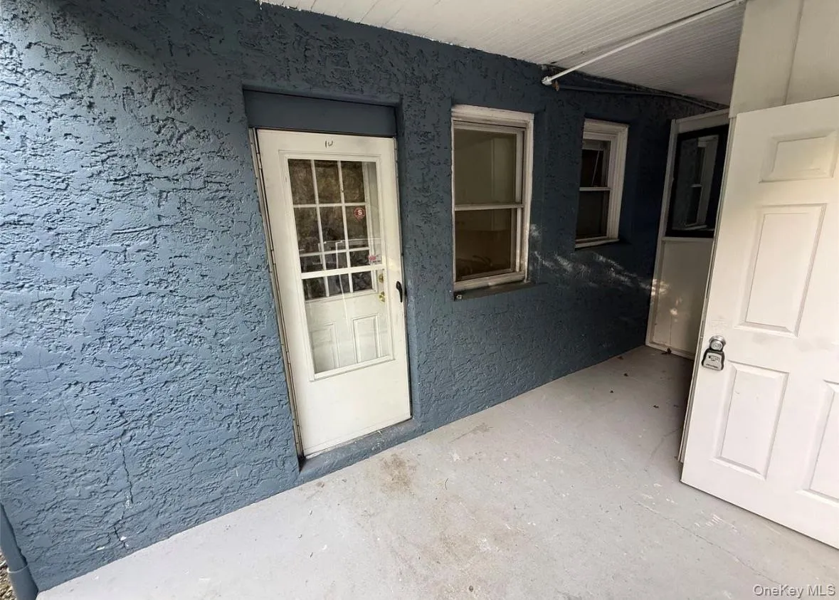 Doorway to property featuring stucco siding Doorway to property featuring stucco siding