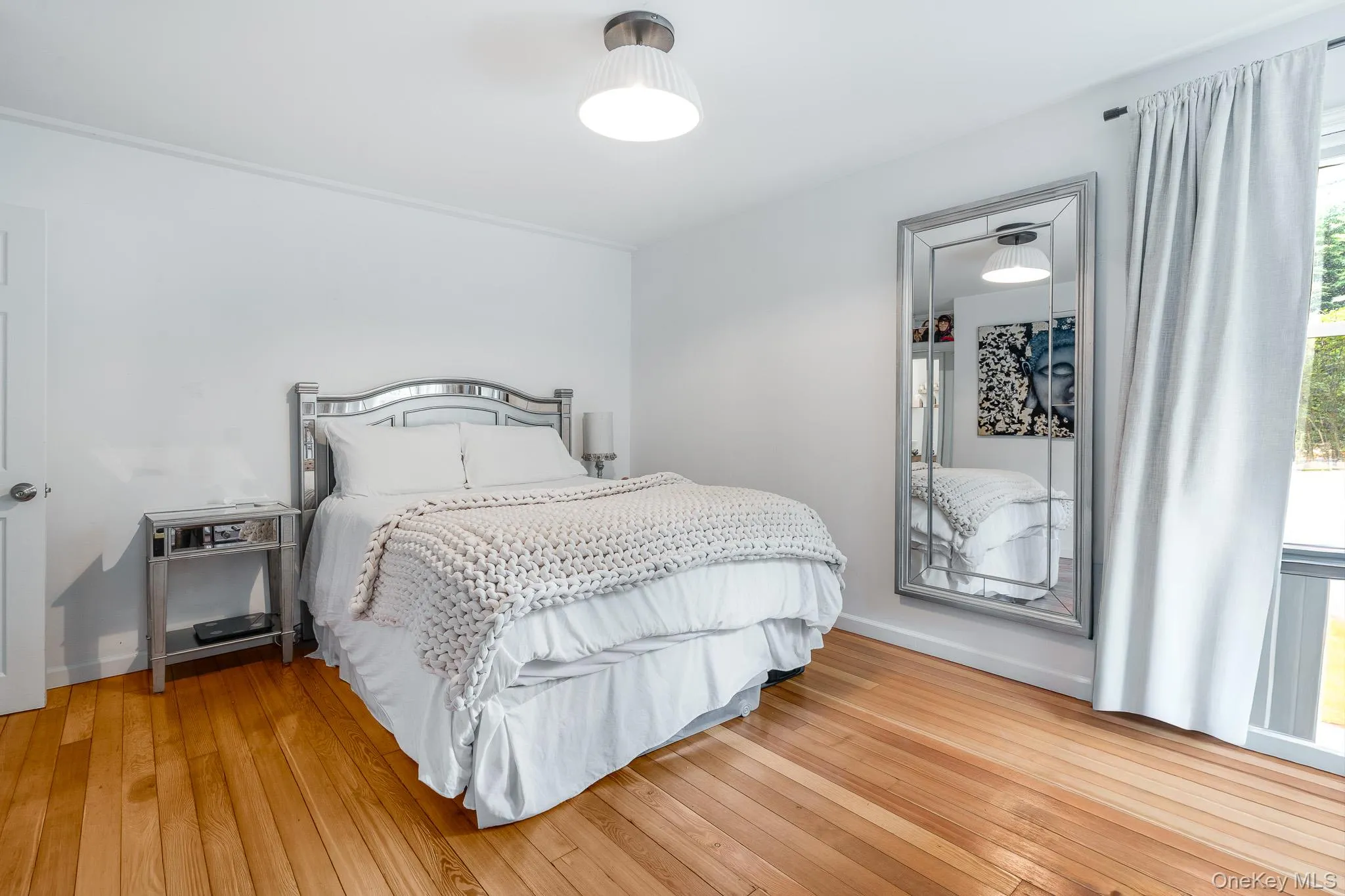 Bedroom with hardwood / wood-style floors and baseboards Bedroom with hardwood / wood-style floors and baseboards