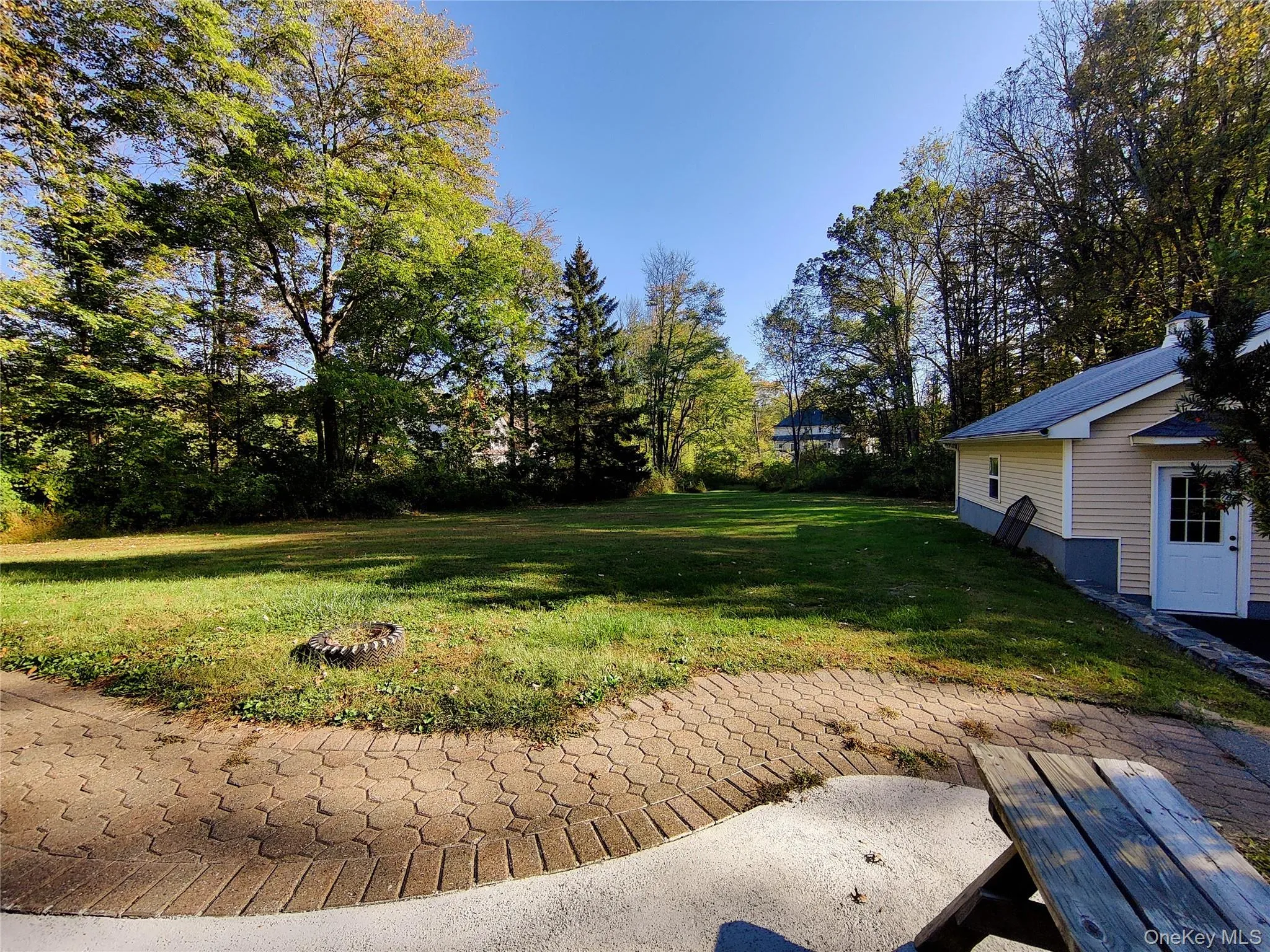 View of green lawn with a patio area and view of scattered trees View of green lawn with a patio area and view of scattered trees