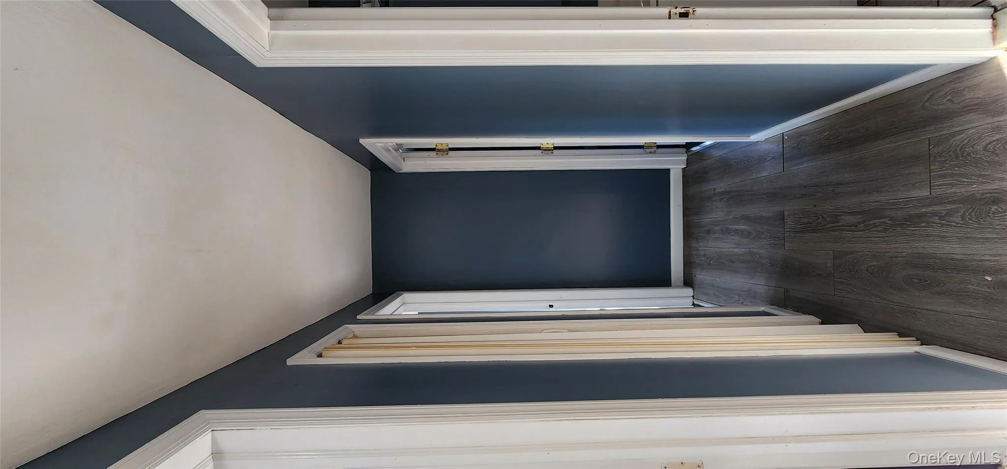 Hall with dark wood-style floors and baseboards Hall with dark wood-style floors and baseboards