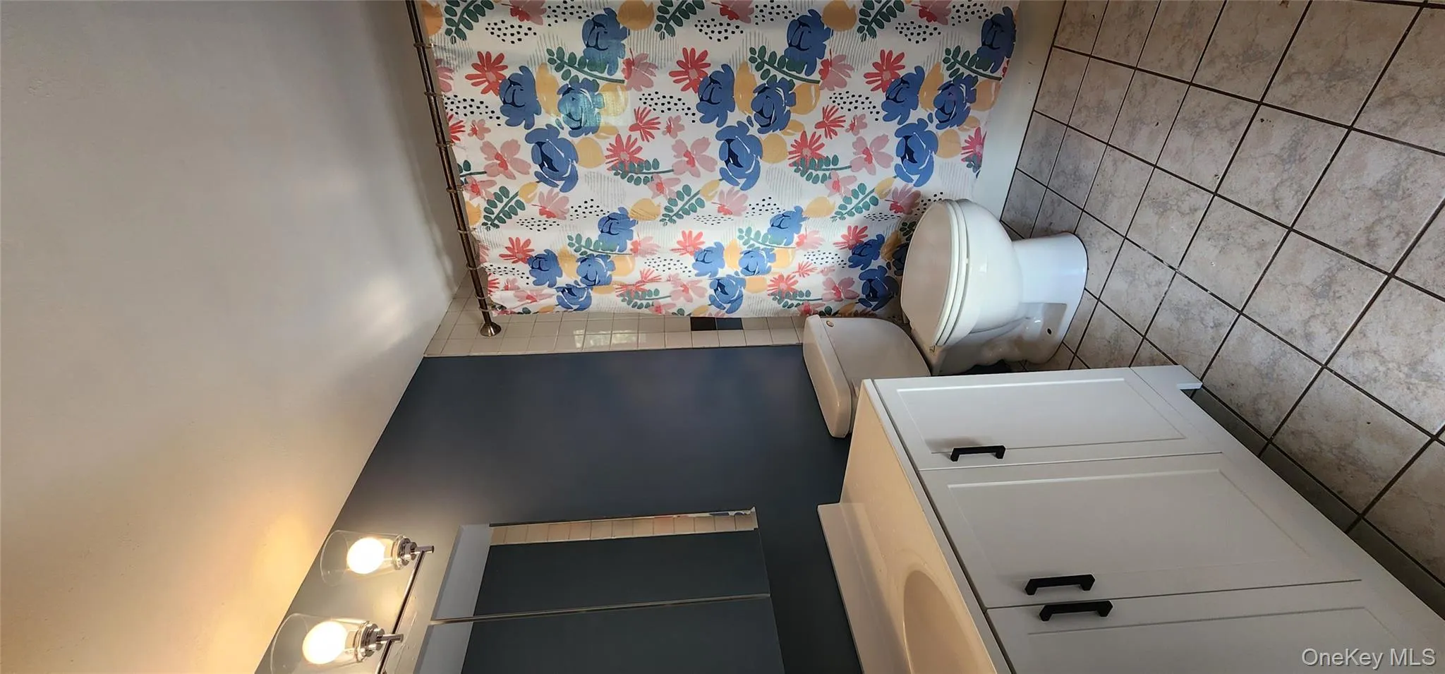 Bathroom with vanity, a shower with curtain, and light tile patterned flooring Bathroom with vanity, a shower with curtain, and light tile patterned flooring